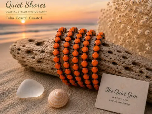 Pre-loved stretch bracelet with bright orange faceted acrylic stones set in a gunmetal-tone setting displayed on a white jewelry stand.