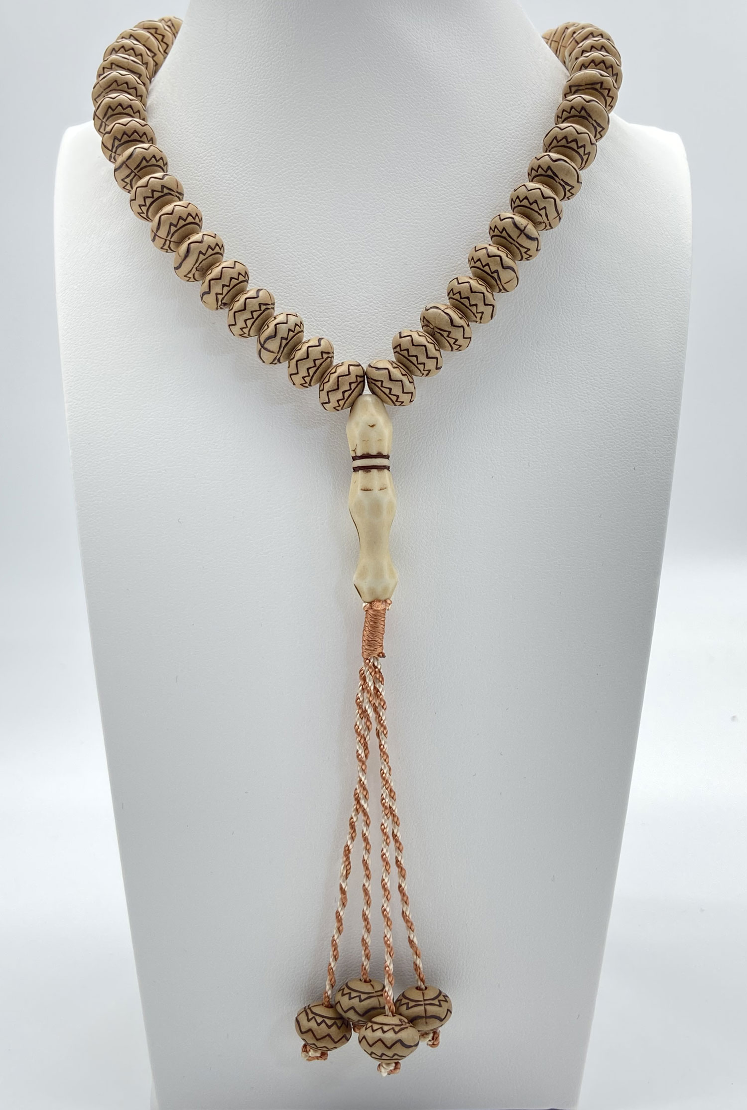 Pre-owned 99 prayer bead necklace with patterned natural-tone beads and long copper-tone tassel strands.
