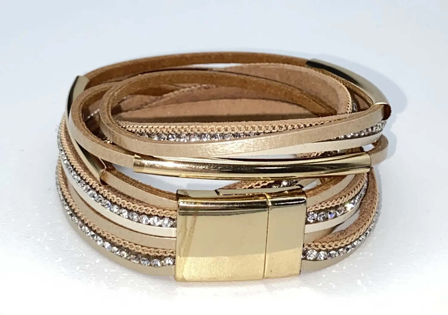 Pre-loved beige multi-layer leather wrap bracelet featuring sparkling rhinestone bands, gold tone chain accents, and a magnetic clasp displayed on a white jewelry stand.