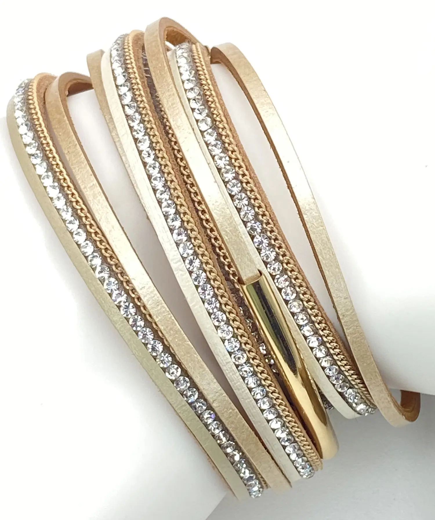 Pre-loved beige multi-layer leather wrap bracelet featuring sparkling rhinestone bands, gold tone chain accents, and a magnetic clasp displayed on a white jewelry stand.