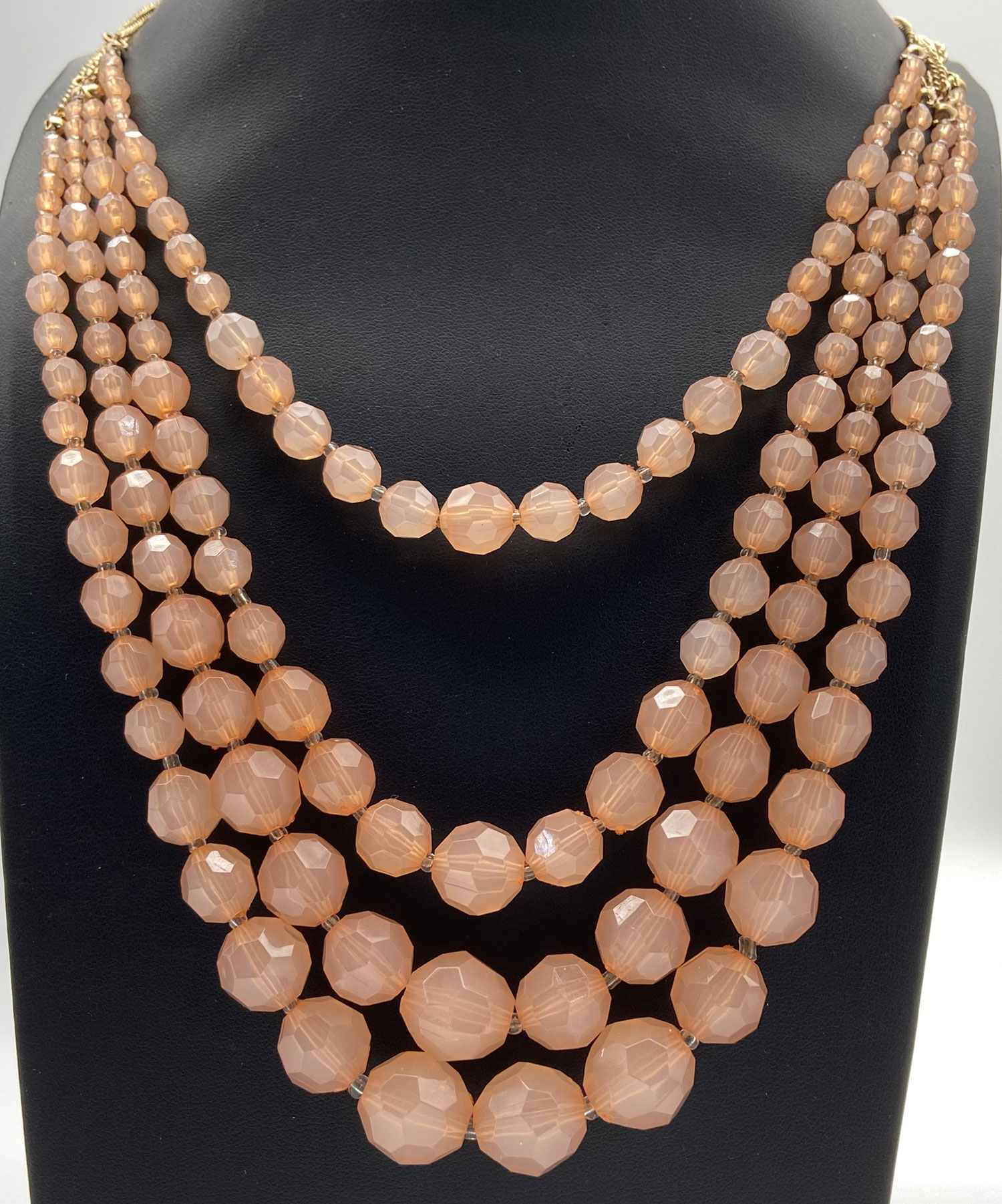 Pre-owned peach Lucite graduated multi-strand necklace with gold-tone accents and 2-inch extension