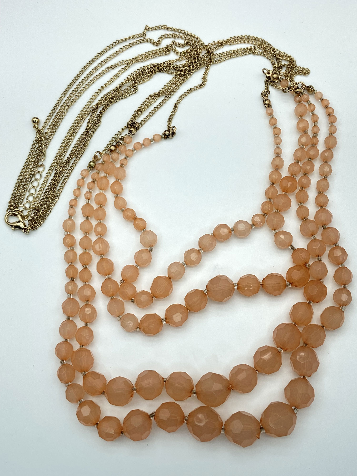 Pre-owned peach Lucite graduated multi-strand necklace with gold-tone accents and 2-inch extension