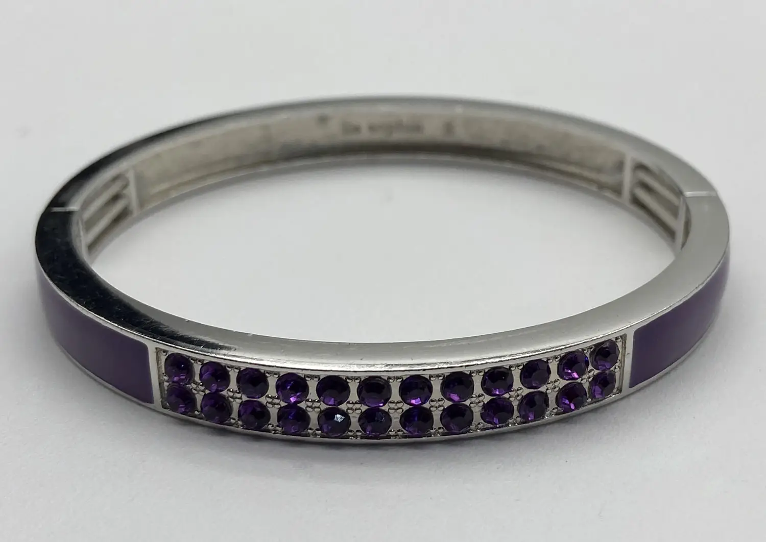 Retired Lia Sophia "Pop Rocks" silver tone fold-over stretch bracelet featuring glossy purple enamel and sparkling purple crystal accents displayed on a white jewelry stand.