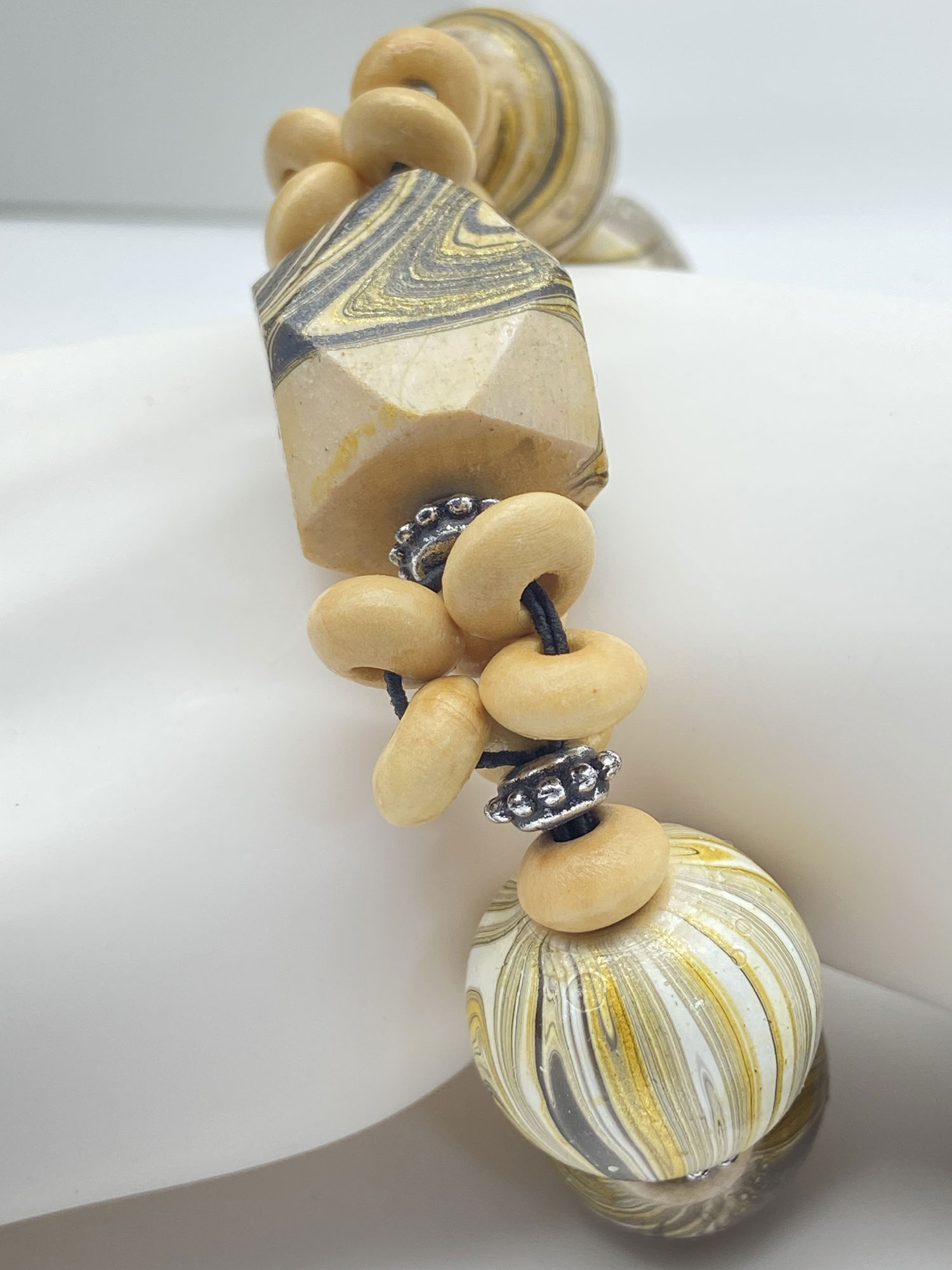 Pre-owned large wood bead bracelet with swirling cream, gold and black patterned beads and silver-tone accents