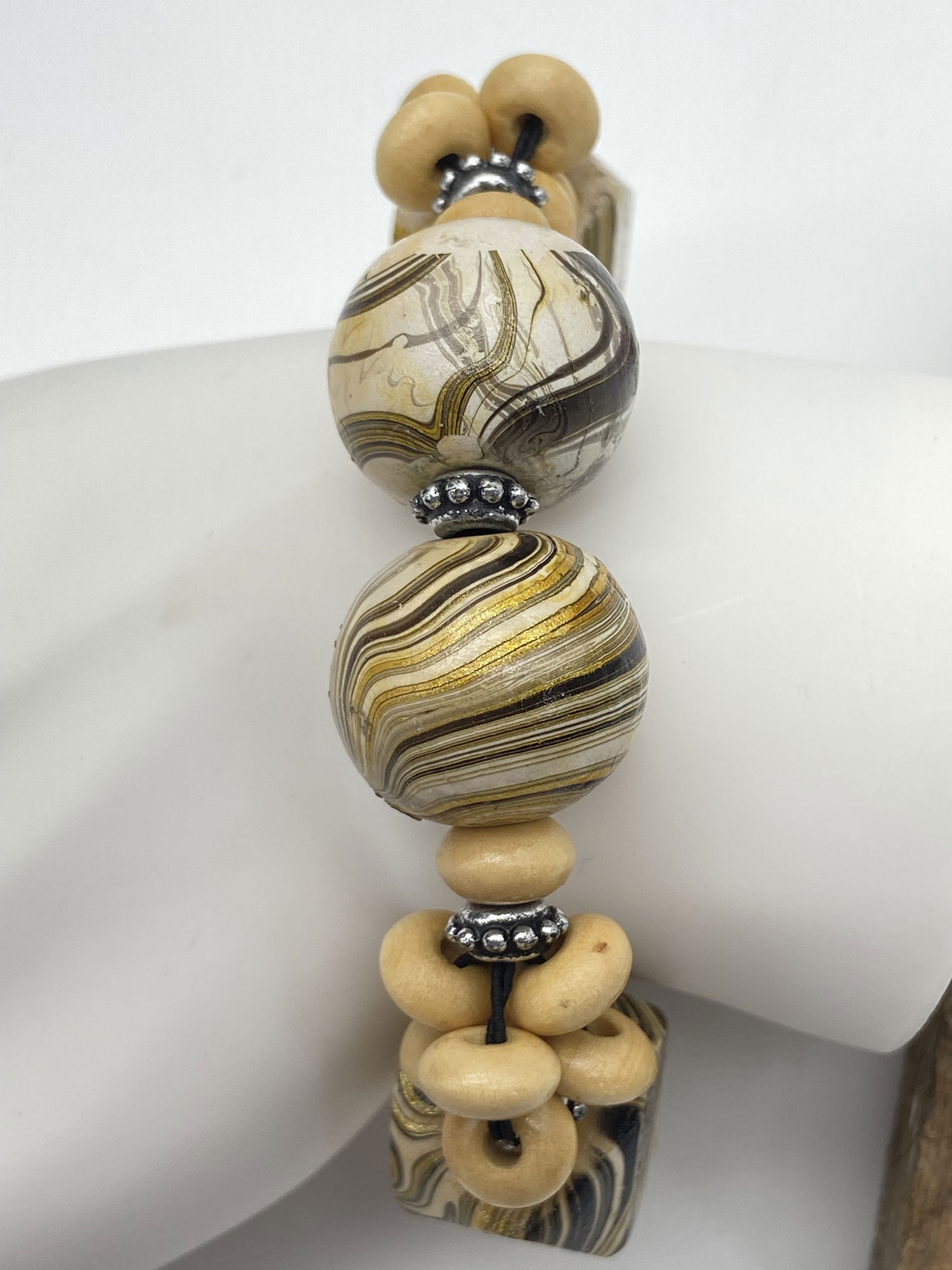 Pre-owned large wood bead bracelet with swirling cream, gold and black patterned beads and silver-tone accents