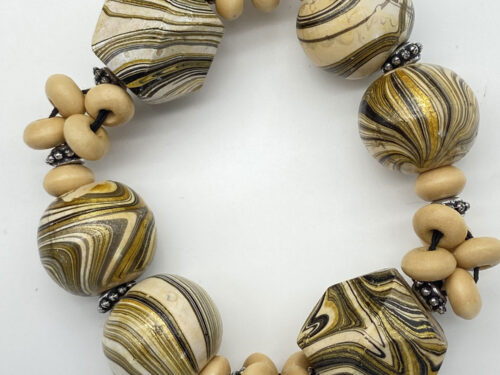 Pre-owned large wood bead bracelet with swirling cream, gold and black patterned beads and silver-tone accents