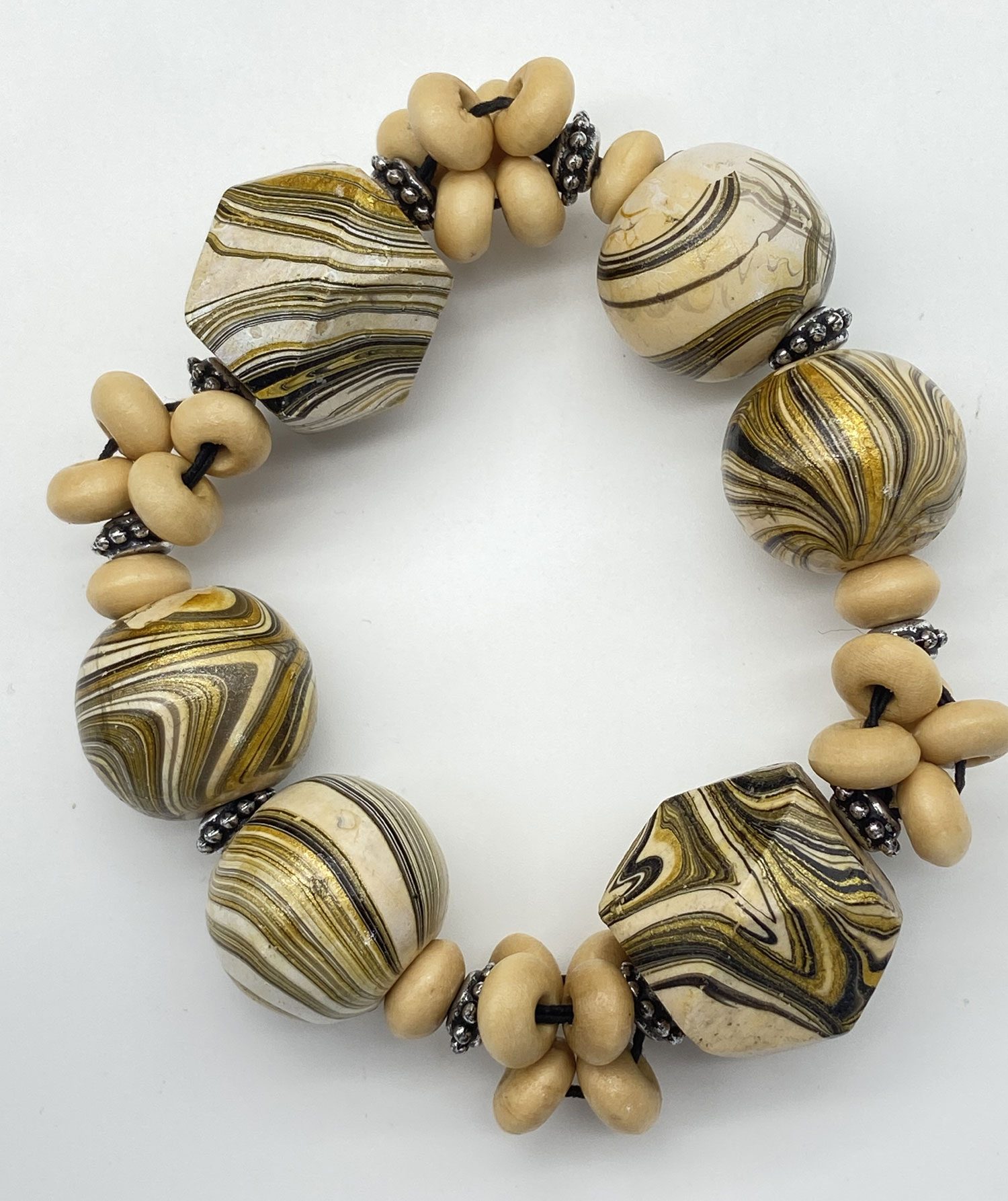 Pre-owned large wood bead bracelet with swirling cream, gold and black patterned beads and silver-tone accents