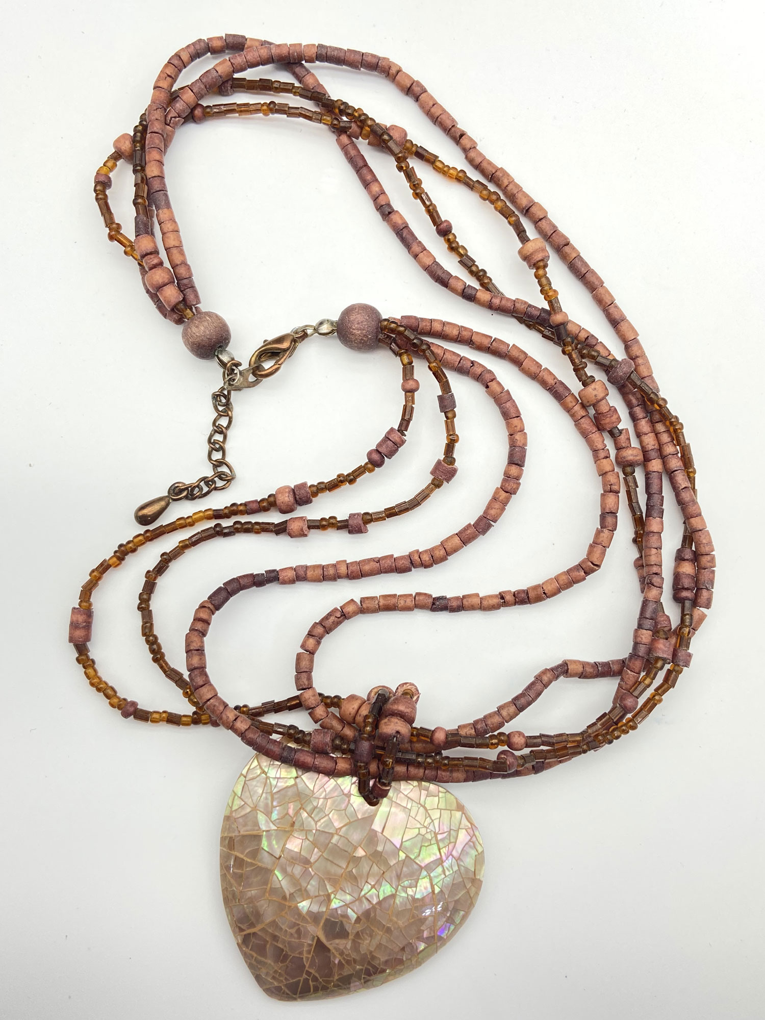 Pre-owned multi-strand wood beaded necklace with earthy brown beads and an iridescent mosaic Mother of Pearl heart pendant.