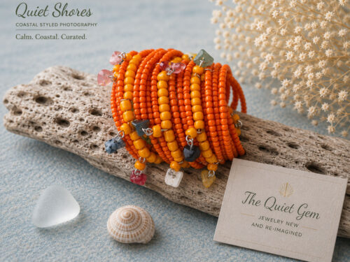 Vintage orange and yellow multi-coil memory wire cuff bracelet with orange seed beads, yellow accent beads, and semi-precious stone chip dangles wrapped around a display stand.