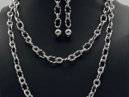 Upcycled silver tone layering chain necklace with matching link earrings displayed on a black jewelry bust