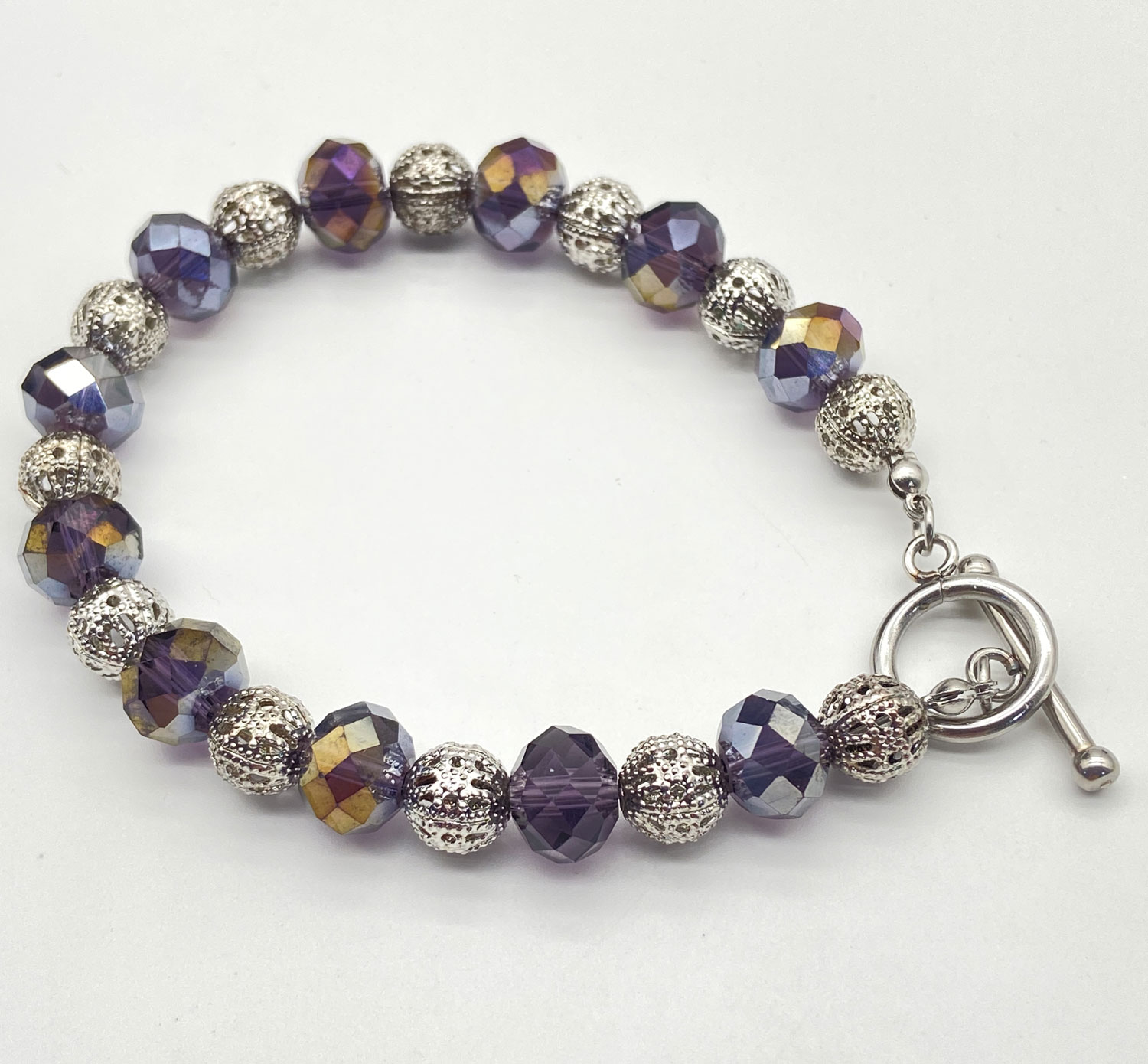 ND Reimagined purple faceted glass bead bracelet with iridescent AB accents, silver-tone filigree beads, and a toggle clasp.