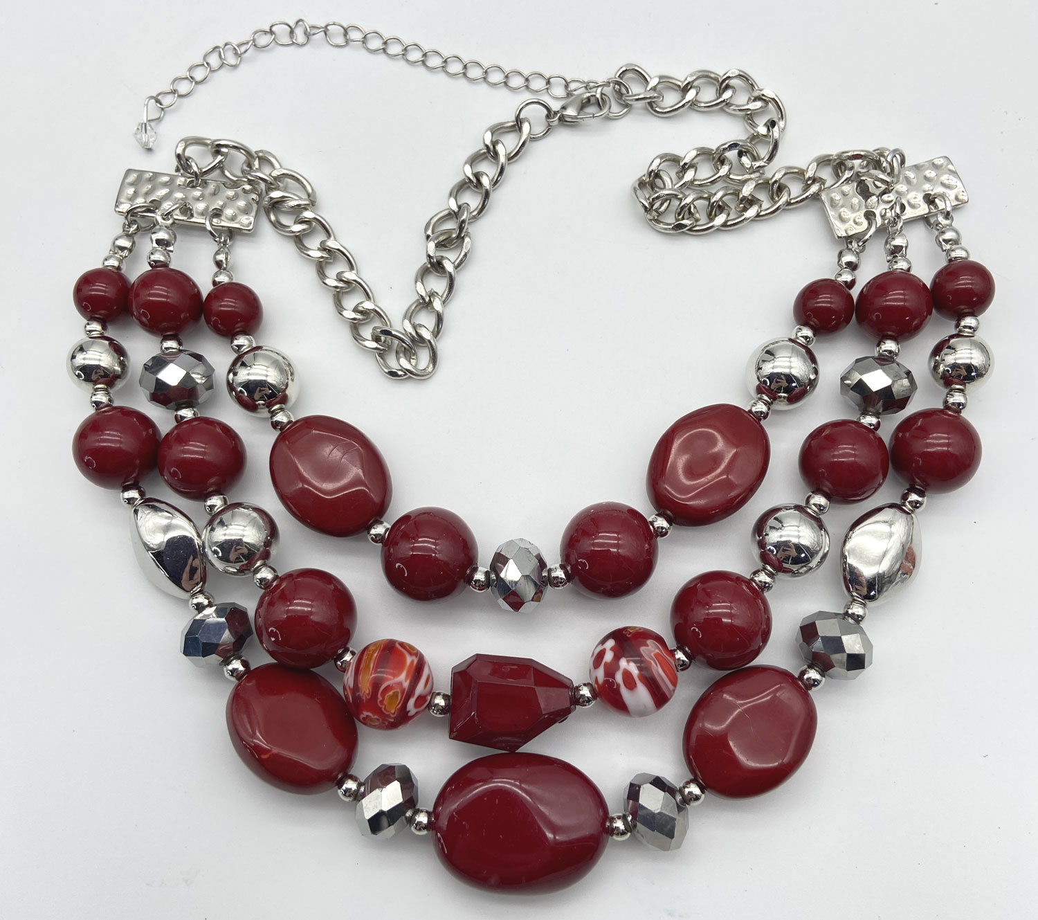Three-strand dark red faux bead necklace with colourful Millefiori-style beads and silver-tone accents, adjustable from 16 to 23 inches.