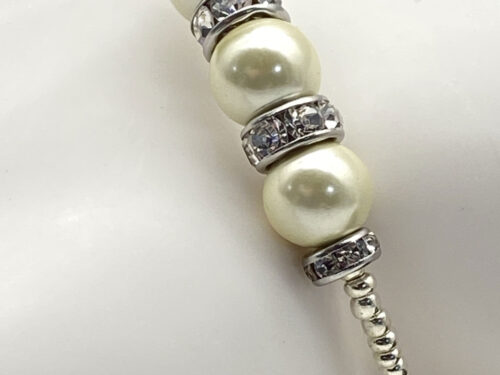 Reimagined ivory faux pearl memory wire bracelet with rhinestone rondelles and silver-tone electroplated magnetic hematite beads.