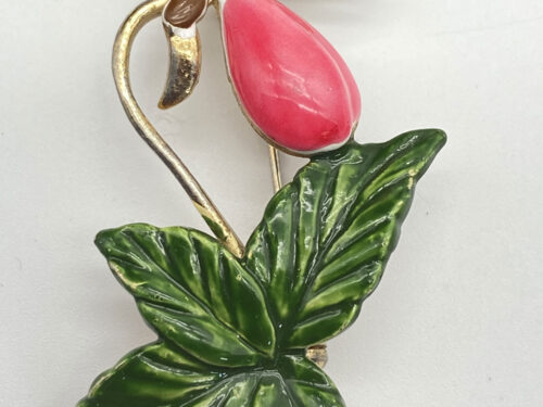 Vintage gold-tone brooch featuring a pink enamel flower bud, green enamel leaves, and curved stems.